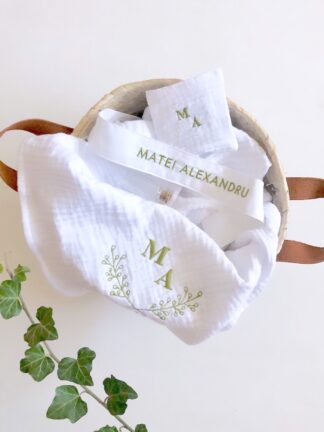 Trusou botez personalizat elegant materiale naturale muselina Trusoul contine: Prosop/paturica pentru micut, personalizata din muselina organica alba  triplustrat, un material premium 100% natural, moale, absorbant, apreciat mai ales pentru articole destinate bebelusilor. Dimensiune prosop/paturica: 90x90 cm  Prosop mediu pentru preot muselina triplustrat, dimensiuni  40x40 cm Panza de mir din finet - bumbac 100%, dimensiuni 90x90 cm  Fasa, dimensiuni  120 cm din bumbac 100%,  personalizata cu numele micutului si data botezului Sticluta pentru ulei, dimensiuni 7-8 cm  Sapun artizanal, 100% natural, fara iritanti sau uleiuri esentiale cu potential alergen, formulat special pentru pielea sensibila a bebelusilor, cu galbenele. Sapunul vine impachetat in hartie de matase si un saculet din bumbac, personalizat cu initiala miculutui. Cutia contine si o urare speciala pentru cel mic si un accesoriu din natura ( pampas, flori nemuritoare, grausor - in functie de sezon ) Trusoul vine ambalat in cutie carton hard - alb texturat, personalizat cu print monograma si numele micutului. Se poate personaliza in orice nuanta.           Disponibil si in alte variante de ambalare/continut, se pot vizualiza in aceeasi categorie - https://www.motifs.ro/categorie-produs/articole-botez-aniversari/trusouri/, dar si in varianta pentru fetita https://www.motifs.ro/shop/articole-botez-aniversari/trusouri/trusou-botez-personalizat-elegant-materiale-naturale/           Va rugam sa notati in comentarii toate detaliile legate de personalizare ( nuanta, piese, nume, initiale, data botezului, alte mentiuni ce considerati a fi relevante ).            Fiind un produs personalizat, comanda se va confirma prin e-mail sau telefonic si dupa achitarea unui avans si este un produs nereturnabil.           Termenul de executie-livrare este de 5-7 zile LUCRATOARE, la care se adauga 24-48 ore pentru transport. Livrarea se va face prin Fan Courier preponderent, insa in functie de destinatie, putem alege si alte companii de curierat, sau in zonele cu km suplimentari serviciul de coletarie rapida door to door al Postei Romane, Prioripost. Pentru a verifica acoperirea standard, https://www.fancourier.ro/acoperire/. Disclaimer:  Cosuletul are rol de prezentare/decorativ, nu este parte a trusoului, desi poate fi o sugestie de utilizat in functie de tematica botezului. Poate fi achizitionat din magazinele de home-deco,insa gasiti o varianta de ambalare in cutie din lemn, personalizata prin gravura, in aceeasi sectiune - articole botez, in cazul in care doriti un ambalaj mai deosebit. Trusou botez personalizat elegant din materiale naturale